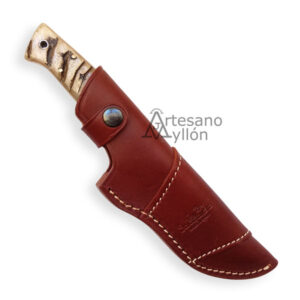 Cuchillo Salamandra Nanuk 501453 parcialmente enfundado en una funda de cuero marrón cosida a mano, dejando visible el mango de asta de carnero.