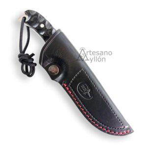 Cuchillo Muela Husky 10M-DX enfundado en una funda de piel negra con costuras rojas, pasador de cinturón y botón grabado, con el mango parcialmente visible.