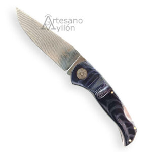 Navaja Muela Navalia 10M-DX abierta, con hoja de acero DAMAX de 135 capas y mango de micarta pulida negra con separadores rojos, sobre fondo blanco.