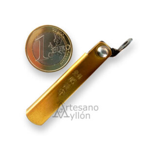 Navaja japonesa Nagao Higonokami cerrada con mango de latón grabado, acompañada de una moneda de 1 euro para mostrar su tamaño compacto.