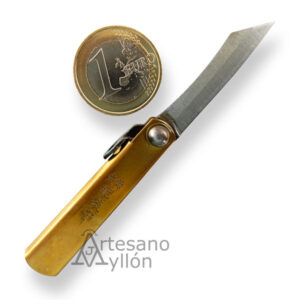 Navaja japonesa Nagao Higonokami abierta con hoja de acero carbono SK de 3,5 cm y mango de latón grabado, mostrada junto a una moneda de 1 euro para escala.