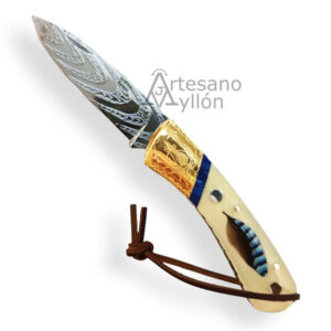 Navaja Miguel Nieto ART2 completamente abierta, con hoja de acero Vanadio grabada a mano y mango color hueso con inserción de pluma natural de arrendajo, virola de latón grabada y cordón de cuero.