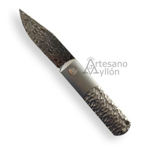 Navaja Böker BRLW 110673DAM abierta con hoja clip point de acero Damasteel con patrón damasco visible y mango de titanio con acabado martillado tipo meteorito, mostrada sobre fondo blanco.