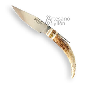 Navaja Celaya Punta Ciervo CA-8 abierta sobre fondo claro, con hoja satinada de acero inoxidable 440 de aproximadamente 9 cm y mango curvado fabricado en asta de ciervo natural decorada, mostrando tonos crema y marrón con veta orgánica y sistema de apertura manual con palanca metálica.