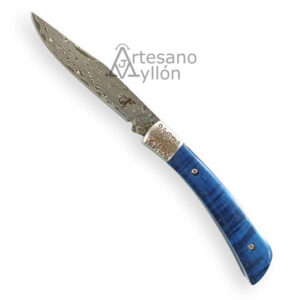 Navaja Salamandra Tek 840525 abierta sobre fondo blanco, con hoja de acero inoxidable laminado tipo Damasco de 83 mm con patrón ondulado visible y mango azul de madera de abedul estabilizada, con virola decorada en acero inoxidable grabado.