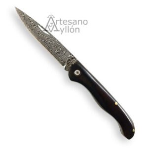 Navaja Tramuntana N202E abierta mostrando hoja de acero damasco VG10 de 67 capas con dibujo ondulado visible y mango curvado de madera de ébano oscuro pulido con remaches metálicos.