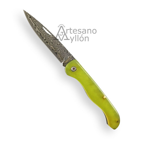 Navaja Tramuntana N202V abierta con hoja de acero Damasco VG10 de 67 capas y mango verde fluorescente translúcido, mostrando el dibujo ondulado del damasco y el sistema de bloqueo de pistón.
