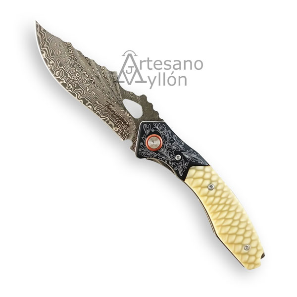 Navaja Tramuntana N197S abierta con hoja de acero damasco VG10 de 67 capas con patrón ondulado visible, apertura mediante orificio, mango acrílico JUMA en tono marfil claro con textura escamada y detalles grabados en la zona metálica.